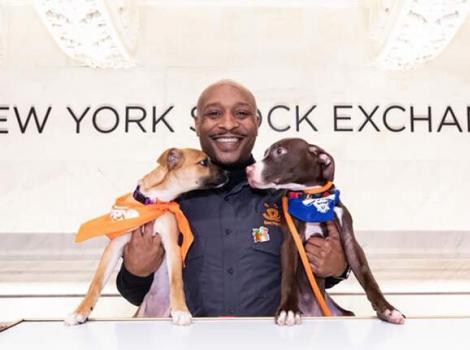 Marlan Roberts holding two puppies at the New York Stock Exchange
